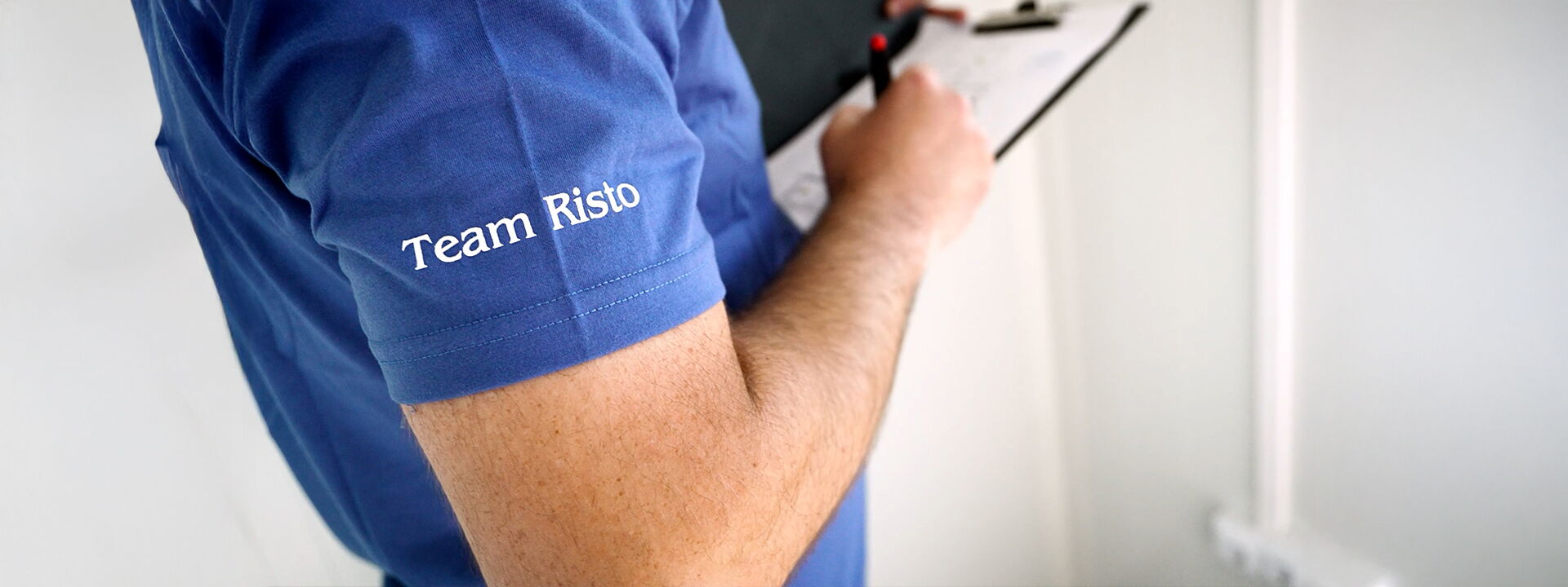 Medewerker bij de kwaliteitscontrole met checklist en opschrift Team Risto      