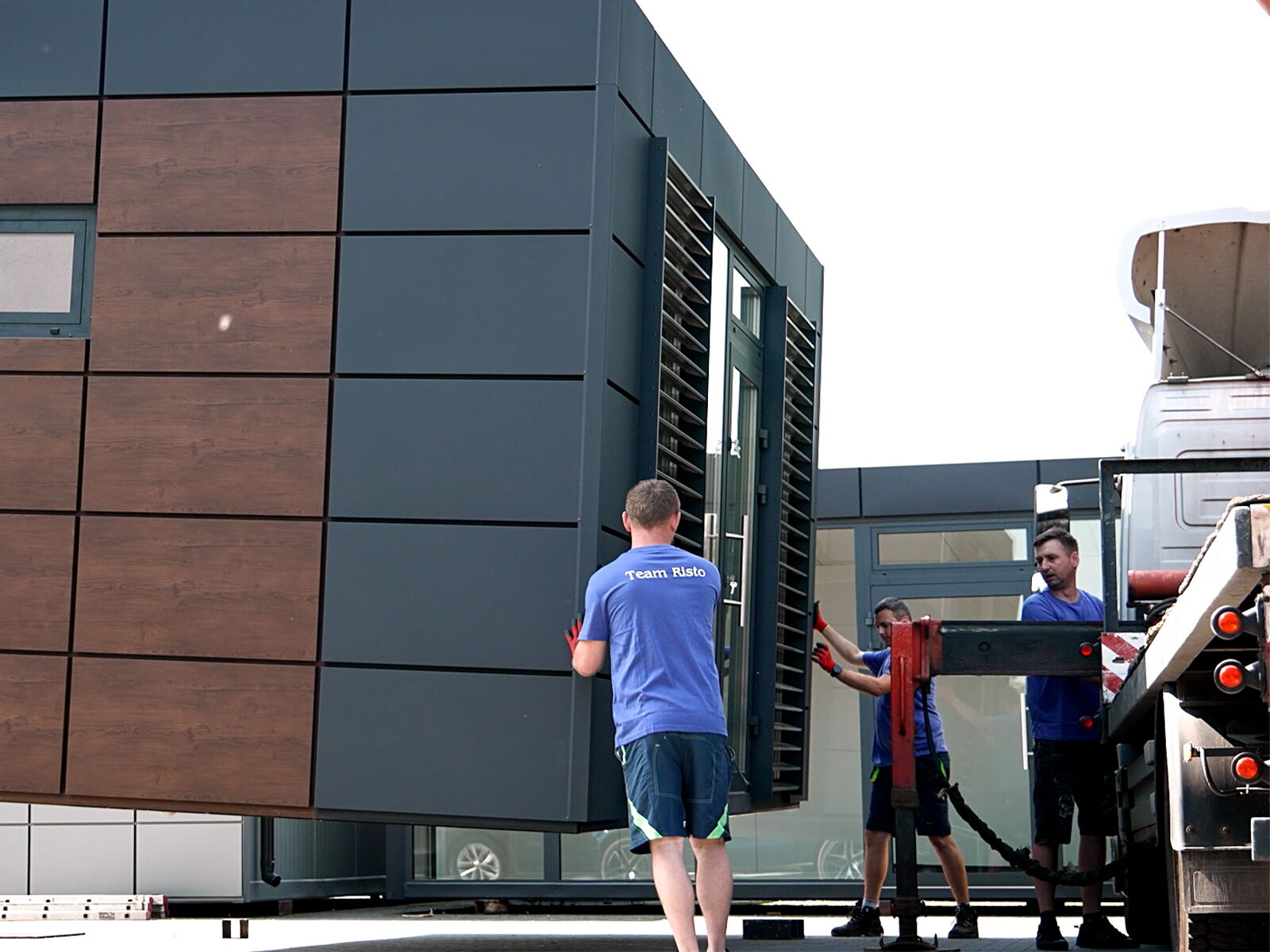 Montage van een kantoorcontainer met hout- en metalen gevel door serviceteam      